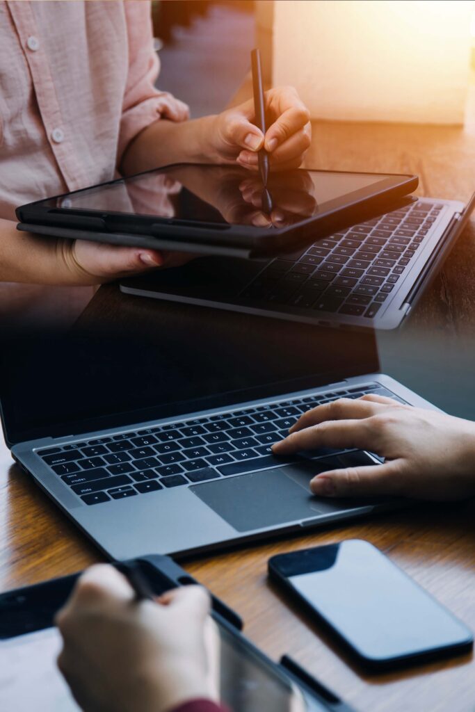 Person using tablet and laptop at desk