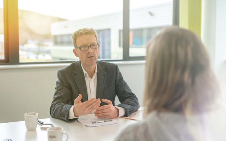 Steve Heathcote speaking with a client during a financial planning meeting
