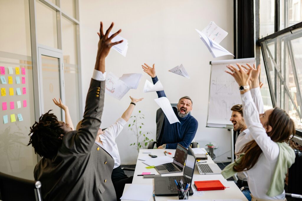 Professional team celebrating success during a meeting in a modern office